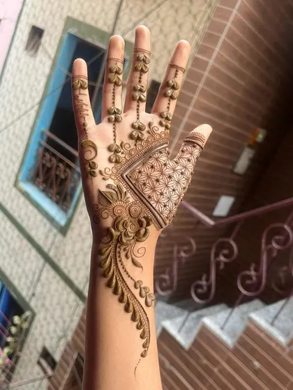 An elegant Arabic-style 'bail' or vine that flows from the wrist to the index finger, adorned with delicate hanging elements.