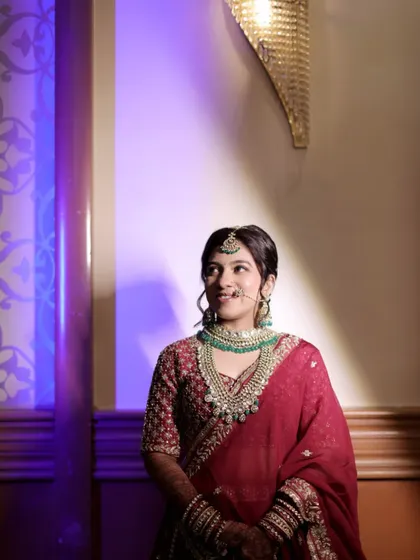 Our bride looks serene and royal in this layered Kundan set with deep green beads, perfectly matching her maroon bridal saree.