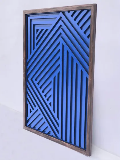 This angled shot of our blue geometric mountain art highlights the depth created by the layered wooden slats. The dark wood frame provides a beautiful contrast to the vibrant blue.