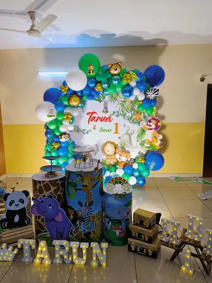 A wider view of the jungle animal party, showing the marquee letters and treasure chest props.
