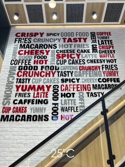 We believe every surface is an opportunity for branding. In this cafe, we transformed a simple wall into a striking feature with a custom typographic mural, integrating the menu's key offerings directly into the interior design for a playful and memorable customer experience.