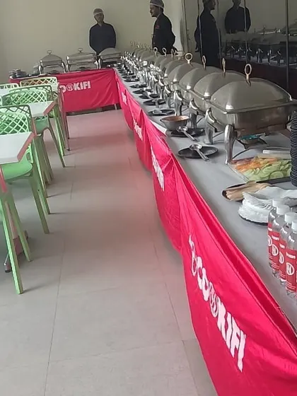 Our buffet line, complete with branded water bottles and neatly stacked plates, ready for service in a corporate cafeteria.