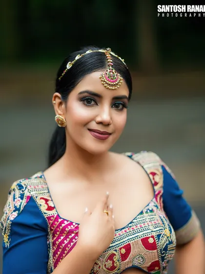 A classic and elegant portrait of a bride looking directly at the camera, highlighting her beautiful makeup and jewelry.