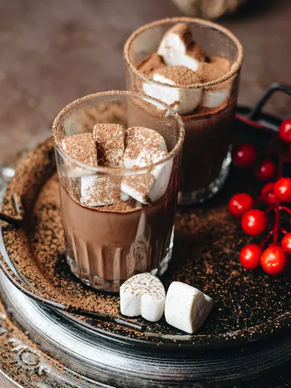 Another take on festive hot chocolate, this time with marshmallows on a vintage tray. The moody lighting and rich colors give it a rustic, cozy Christmas feel.