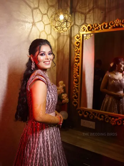 A happy bride posing for a portrait before her event. Her smile is infectious, and the mirror in the background adds a nice depth to the composition.