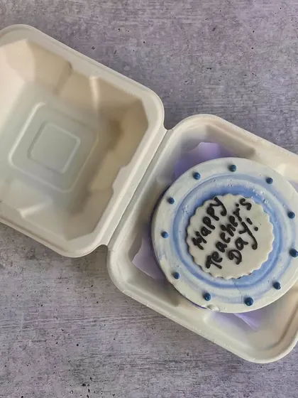 A simple and sweet bento cake for Teacher's Day with a blue and white polka dot border. It's a lovely token of appreciation for any teacher.
