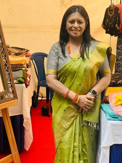 A happy client trying on a saree at our exhibition stall. These interactions are what make our work so rewarding.