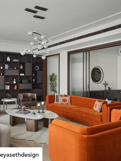 The vibrant orange sofa acts as a centerpiece in this dynamic living room, complemented by a custom bookshelf and organically shaped tables. This space highlights our ability to craft furniture that is both functional and expressive.