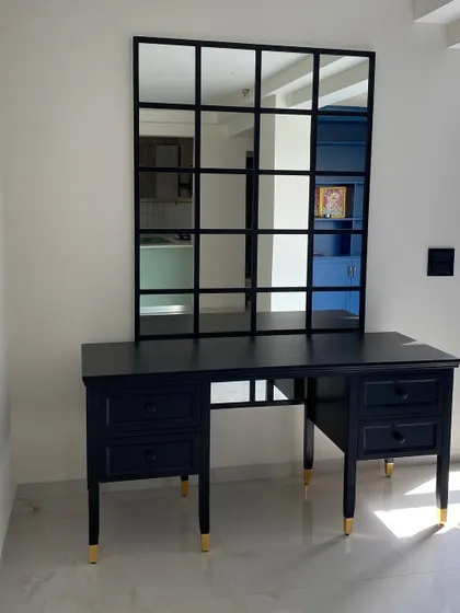 A custom-made black study or dressing table with elegant turned legs and brass-capped feet. Paired with a windowpane mirror, it creates a chic and functional workspace.
