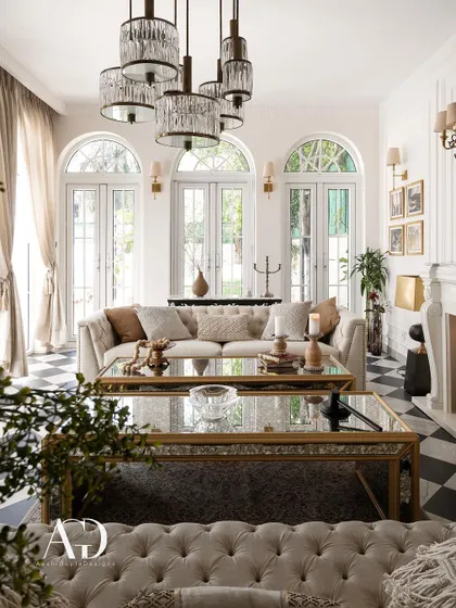 In the spirit of French elegance, this outhouse living room whispers sophistication. Arched French doors, a classic checkerboard floor, and tufted sofas create a refined yet relaxed atmosphere, perfect for an intimate retreat.