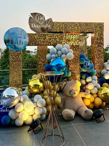 A glamorous rooftop setup for a "Sexy 16" birthday bash. This photo corner features a gold sequin backdrop, a modern balloon arrangement, and a giant teddy bear, creating the perfect spot for stylish teen photos.