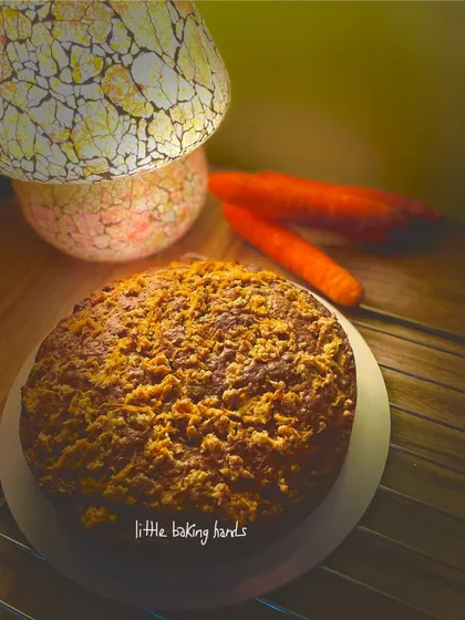 The warm lighting in this photo really brings out the beautiful colours of the carrot cake and its crumble topping.