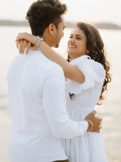 The joy and laughter shared between a couple is what we love to capture. This candid moment from a pre-wedding shoot by the water shows their genuine happiness and carefree spirit.