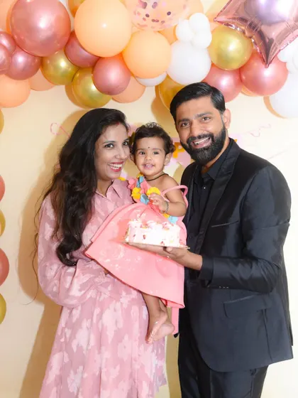 A beautiful, happy family portrait, perfectly capturing the memory of a first birthday.