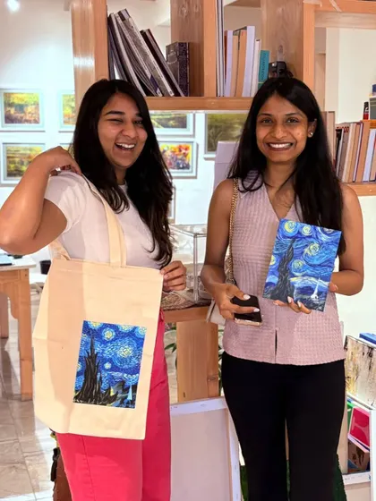 Nothing beats the joy of making something with your own hands. Here are two happy creators at our studio proudly showing off their finished 'Starry Night' canvas and a custom-painted tote bag.