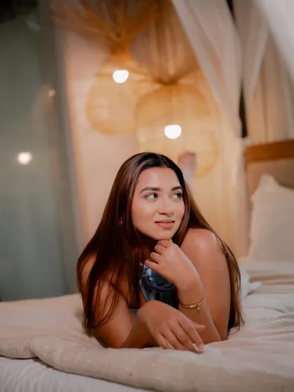 A duplicate of image 203, this cozy and intimate portrait of a model on a bed has a warm and dreamy atmosphere.
