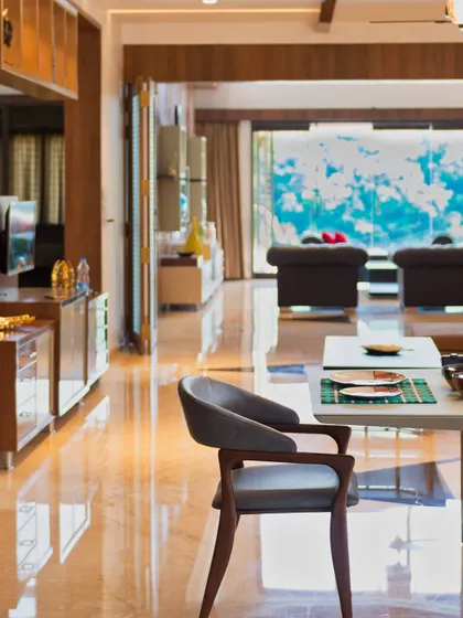 A view from the dining area towards the living room, emphasizing the depth and openness of the floor plan. The high-gloss marble flooring reflects natural light, enhancing the feeling of a bright and airy home.