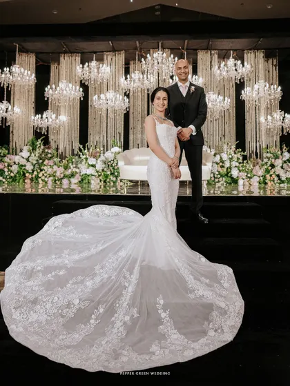 A stunning portrait of the bride and groom, with the bride's magnificent train spread out before them against a backdrop of glittering chandeliers. A moment of pure opulence and romance.