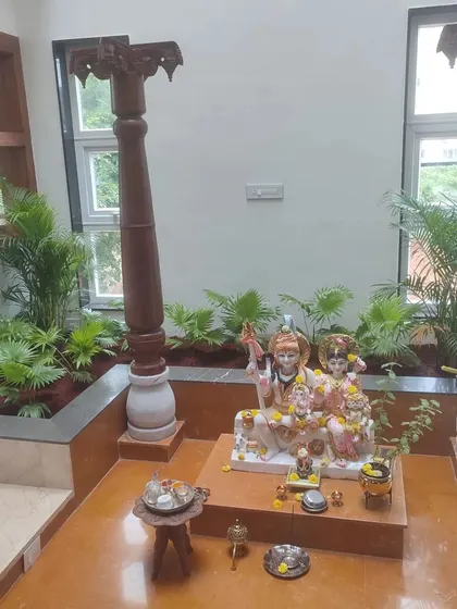 Another angle of the serene indoor garden setup, highlighting the traditional wooden pillars and the lush greenery that fills the space with positive energy.