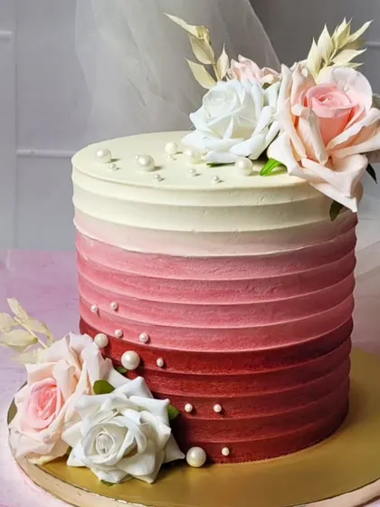 Pretty as a picture. This cake features a beautiful red ombre buttercream texture, decorated with fresh roses for a classic and romantic look.