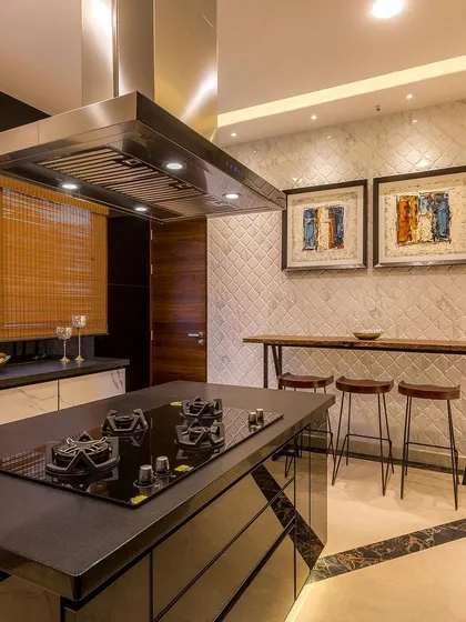 This shot showcases the breakfast bar area, with a raw wood slab and modern stools set against a textured white tile wall.