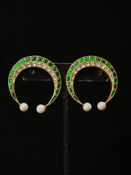 Modern and chic, these crescent-shaped hoop earrings feature green meenakari enamel and are studded with kundan-style stones. A single pearl drop completes this stylish design.