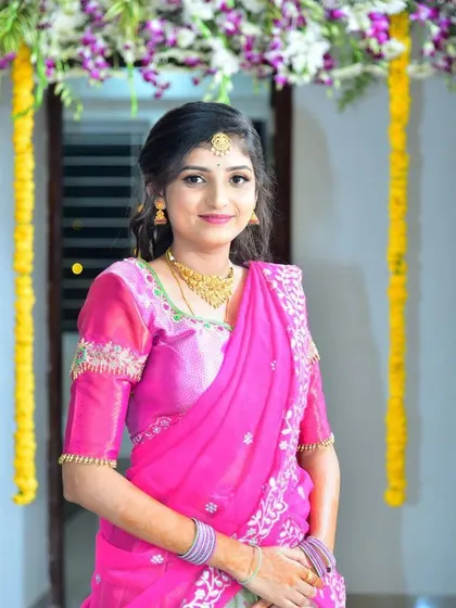 A sweet and simple look. This client's pink half-saree features delicate embroidery along the neckline and sleeves, perfect for a family celebration.