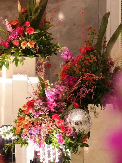 A stunning floral installation for the disco-themed Mehendi, combining bright flowers with a mirrored pedestal and a disco ball.