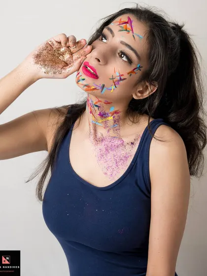 Another angle from the 'Glitter' shoot, showing the model looking upwards. The mix of paint and glitter on her face and neck creates a unique, textured, and artistic portrait.