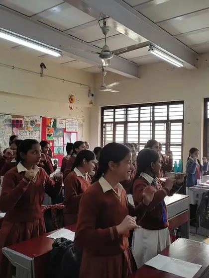 Students stand and participate in a vocal warm-up. We teach the fundamentals of music, including proper vocal techniques, to build a strong foundation for their musical journey.