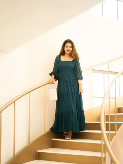 A lifestyle shot for a fashion blogger on a modern, spiral staircase. The location adds architectural interest and an elegant feel to the portrait.