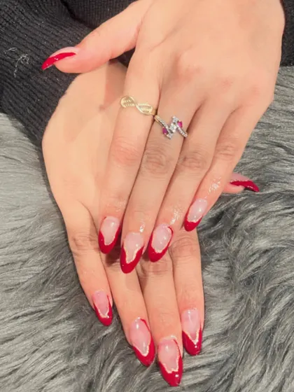Bold and beautiful V-shaped French tips in a classic red. This design on almond nails is both elegant and powerful.