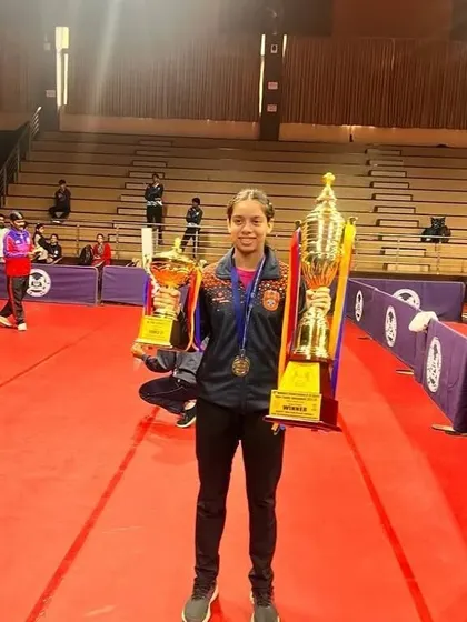 Ananya Chande looking triumphant with her Gold and Silver trophies from the School Games Federation of India (SGFI) games in Indore. Her success in both team and individual events highlights her versatility as a competitive table tennis player.