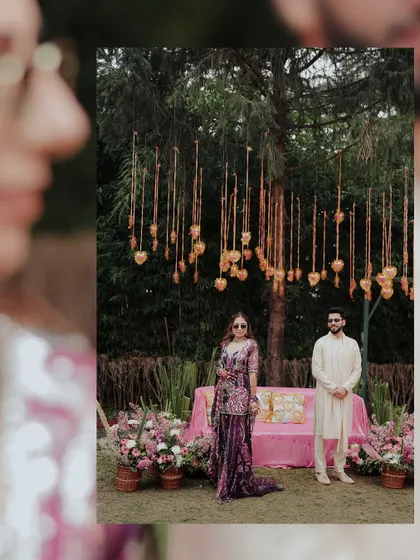 A full-length portrait of the couple at their Haldi event. The unique decor with hanging hearts and floral arrangements creates a beautiful and personalized setting.