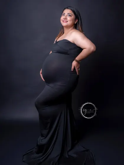 A happy and confident pose from the mom-to-be. Her smile lights up this simple yet elegant portrait in a classic black gown.