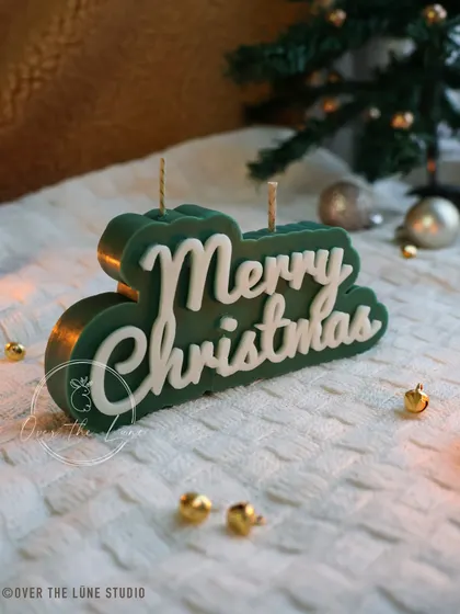 The forest green 'Merry Christmas' candle. It's a simple yet elegant piece that speaks for itself.