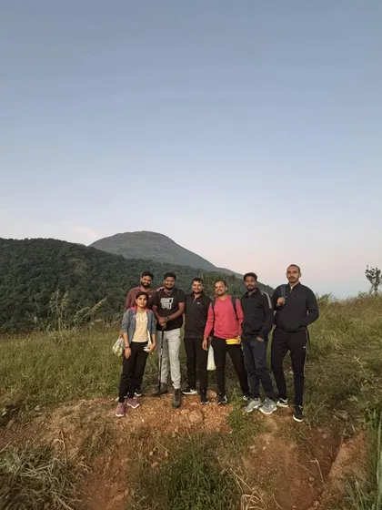 A small group posing on the trail with the mountain peak visible in the background.
