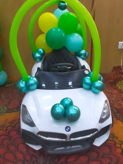 A fun addition to the jungle party: a toy car decorated with balloons for the birthday boy's entry.