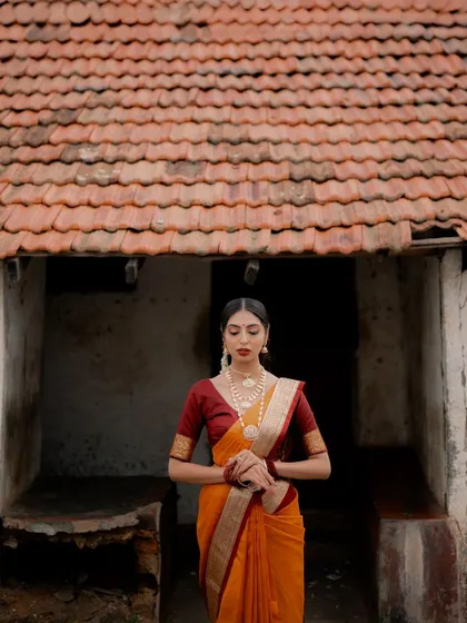A contemplative pose against the backdrop of a traditional home. The bride's posture and expression evoke a sense of timeless grace and heritage.