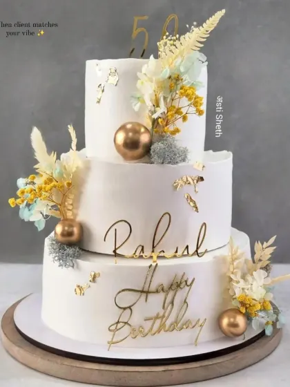 A magnificent three-tiered cake for a 50th birthday. This 6kg Cherry Chocolate cake features dried florals, gold accents, and elegant script.