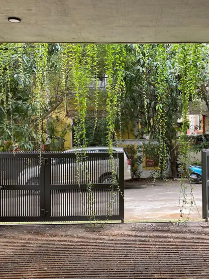 A view from the carport of "House of Greens," looking out through the gate. The cascading greenery frames the view and creates a sense of being enveloped by nature.
