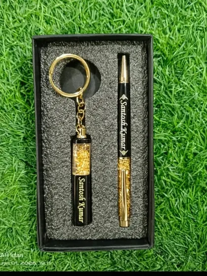 A luxurious personalized pen and keychain set, both featuring a gold flake design and custom name engraving.
