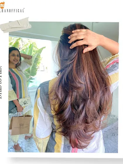 The "after" shot of a mocha balayage transformation. The client is checking out her new look, which features rich, chocolatey hues and subtle highlights.