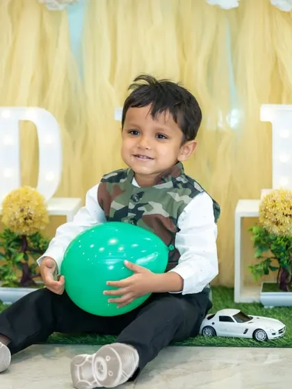 A candid portrait of the birthday boy playing with a balloon during his party. We let kids be kids, capturing their natural expressions and playful energy.