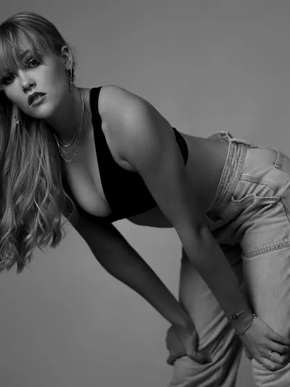 A dynamic pose in black and white. The model leaning into the frame creates an engaging and powerful image that highlights her form and energy.