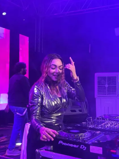 A candid shot of me smiling and pointing to the crowd while mixing a track.