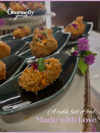 "A table full of food, made with love." This close-up shot of our crispy noodle-wrapped appetizers emphasizes the craft and care that goes into each bite.