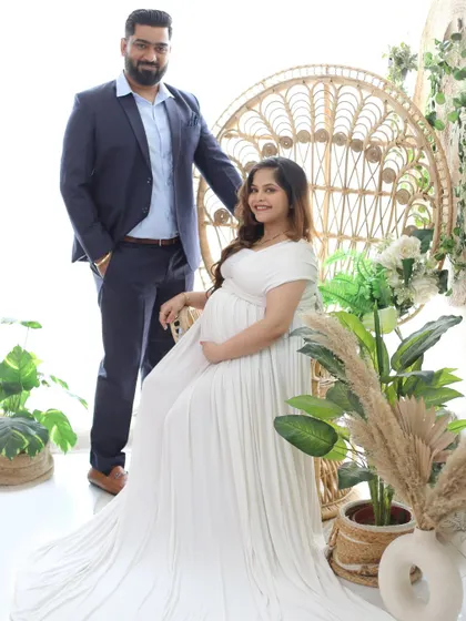 A formal and elegant couple's portrait in our boho-chic studio setup. The contrast between his sharp suit and her flowing white gown creates a beautiful visual balance.