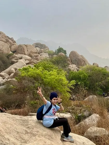 A trekker flashes a peace sign, enjoying the adventure at Anthargange. We focus on creating experiences that are both challenging and fun.