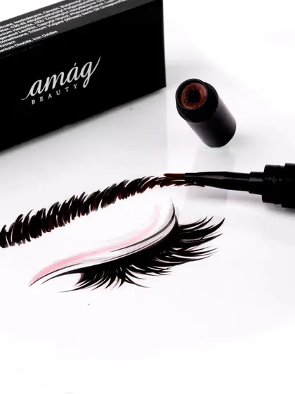 This creative shot demonstrates the product in action. The eyebrow pen creates a perfectly illustrated brow on a clean white surface, showcasing its precision and rich pigment in a visually engaging way.